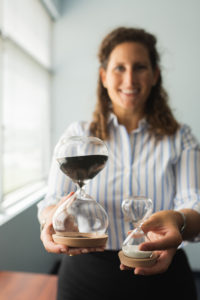 Coach Cassandra holding two glass sand timers.